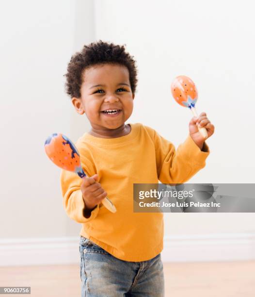 african toddler playing with maracas - maracas fotografías e imágenes de stock