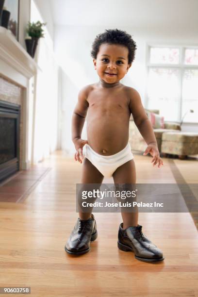 african toddler wearing father's shoes - diaper boy 個照片及圖片檔