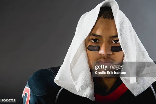 mixed race football player with towel on head - eye black fotografías e imágenes de stock