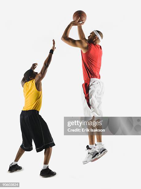 african man shooting basketball over opponent - basketball blocking shot stock pictures, royalty-free photos & images