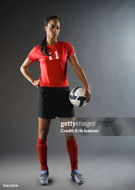 mixed race soccer player holding soccer ball - aggression studio stock-fotos und bilder