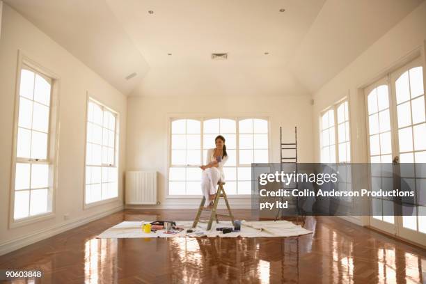 hispanic woman painting room - home renovations australia stock-fotos und bilder