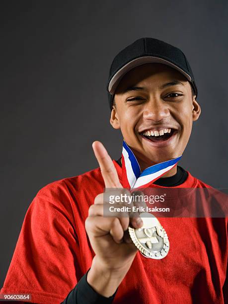 mixed race baseball player gesturing with award medal - sportsperson medal stock pictures, royalty-free photos & images