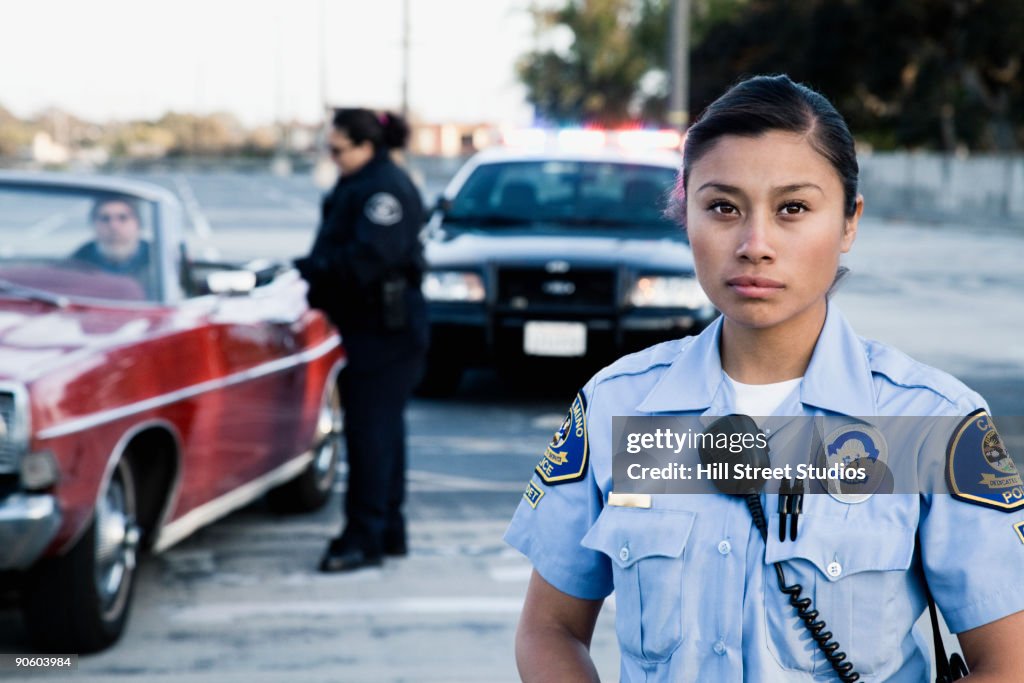 Policewomen pulling over man in convertible