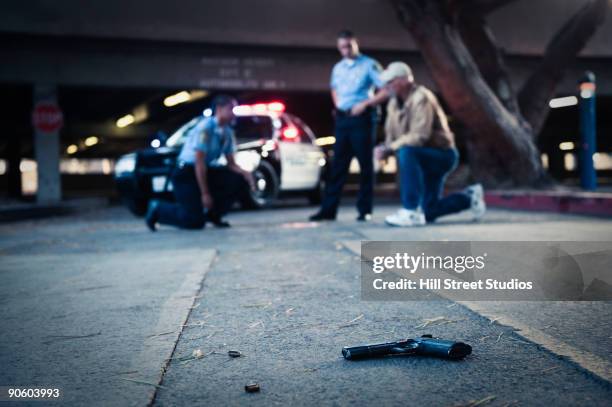 police examining crime scene with gun on ground - police car side view stock pictures, royalty-free photos & images