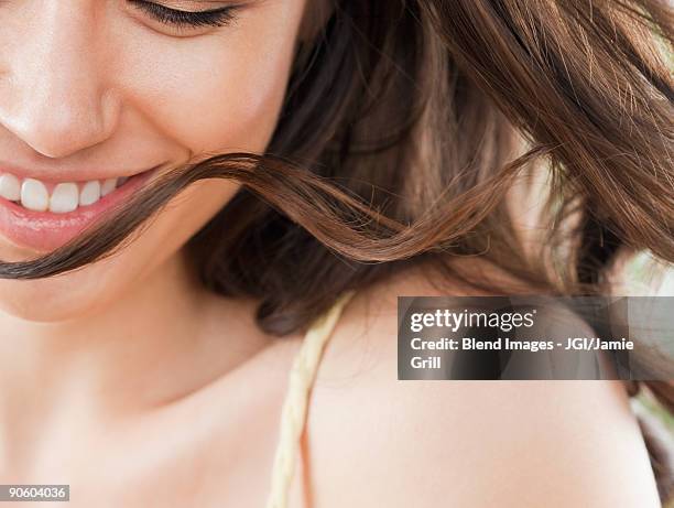 mixed race woman looking down and smiling - capelli lunghi foto e immagini stock