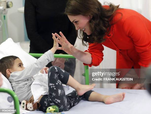 Britain's Catherine, Duchess of Cambridge interacts with patient Rafael Chana during her visit to officially open the Mittal Children's Medical...
