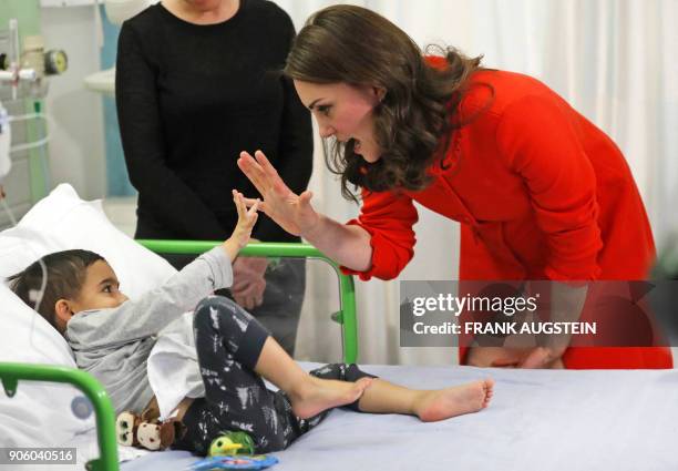 Britain's Catherine, Duchess of Cambridge interacts with patient Rafael Chana during her visit to officially open the Mittal Children's Medical...