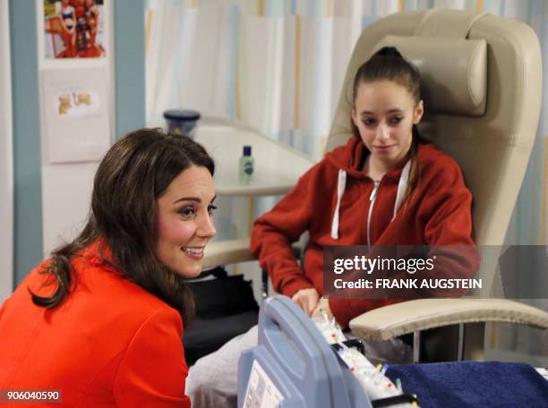 Britain's Catherine, Duchess of Cambridge sits with patient Gabriella Cook during her visit to officially open the Mittal Children's Medical Centre,...