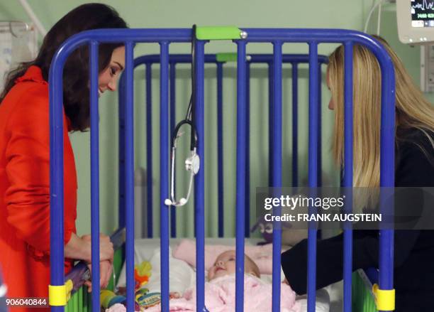 Britain's Catherine, Duchess of Cambridge interacts with six-month old patient Sienna McGuire during her visit to officially open the Mittal...