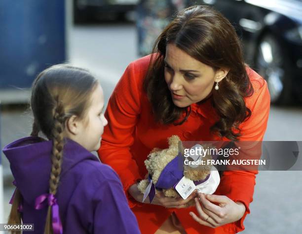 Britain's Catherine, Duchess of Cambridge receives two teddy bears from patient Eva during her visit to officially open the Mittal Children's Medical...