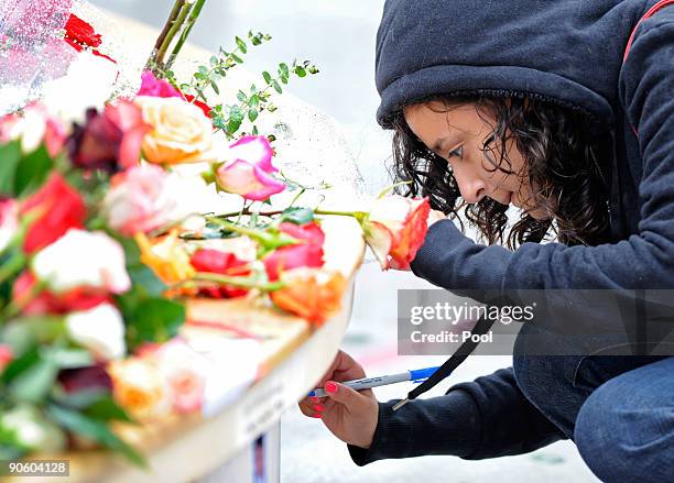 Woman writes on the reflecting pool as she pays her respects at Ground Zero during a 9/11 memorial ceremony on September 11, 2009 in New York City....