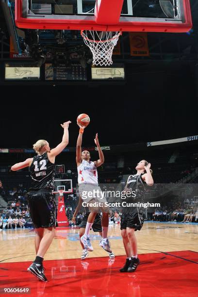Iziane Castro Marques of the Atlanta Dream shoots against Ann Wauters and Belinda Snell of the San Antonio Silver Stars during the game at Philips...