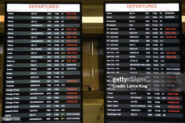Flight status monitors at Raleigh-Durham International Airport indicate several flights as delayed or cancelled on January 17, 2018 in Morrisville,...