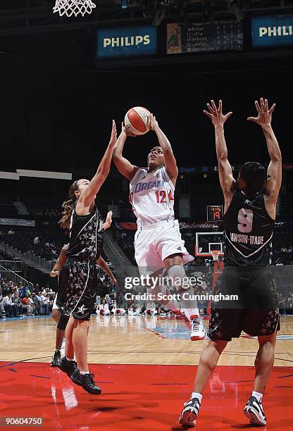 Ivory Latta of the Atlanta Dream takes the ball to the basket against Becky Hammon and Edwige Lawson-Wade of the San Antonio Silver Stars during the...