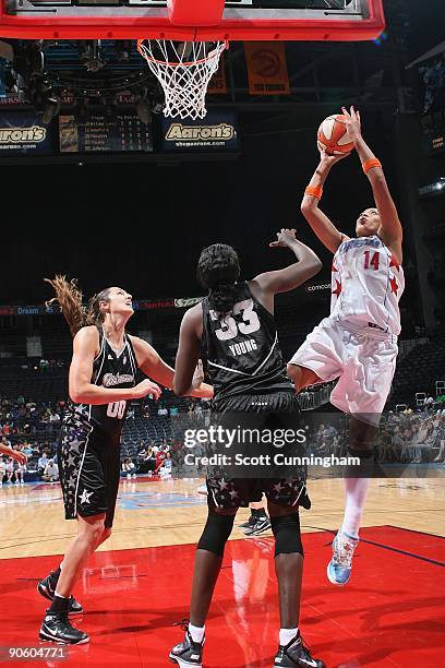 Erika de Souza of the Atlanta Dream shoots in the key against Ruth Riley and Sophia Young of the San Antonio Silver Stars during the game at Philips...