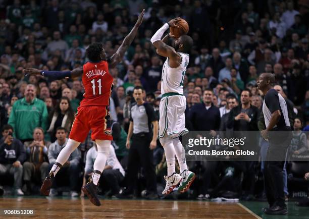 With New Orleans leading 116-113 in overtime, the Celtics' Kyrie Irving, right, tries to tie the game with a three point attempt with under five...