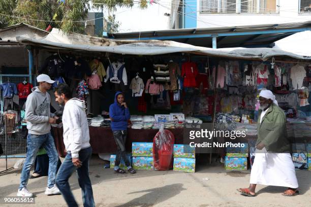 Palestinian vendor stands outside his store in al-Nusirat refugee camp in the Gaza strip on January 17, 2018. Gazans are strapped for cash and...