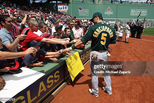 Nomar Garciaparra of the Oakland Athletics signs autographs for fans prior to the game against the Boston Red Sox at Fenway Park on July 30, 2009 in...