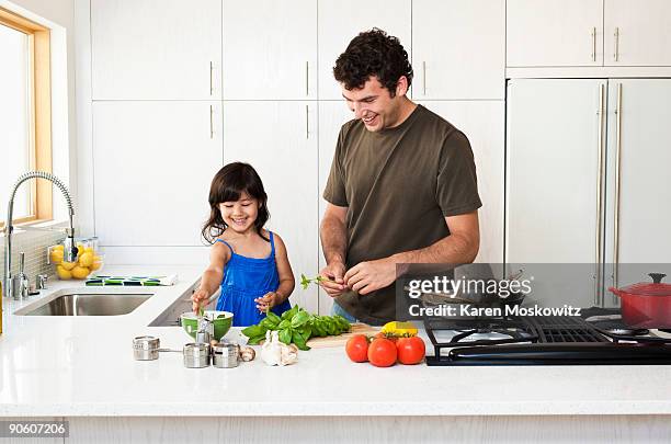 man cooking with daughter - kitchen cooking family stockfoto's en -beelden