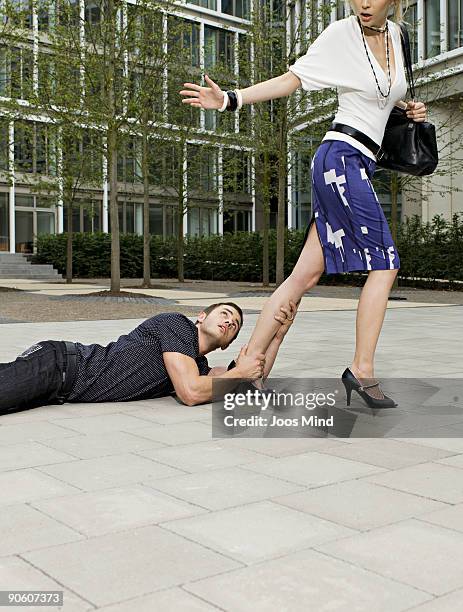 man holding onto womans leg, as she walks away - begging stockfoto's en -beelden