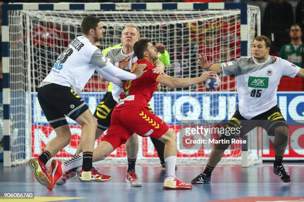 Filip Kuzmanovski of Macedonia is challenged by Hendrik Pekeler of Germany and Paul Drux of Germany during the Men's Handball European Championship...
