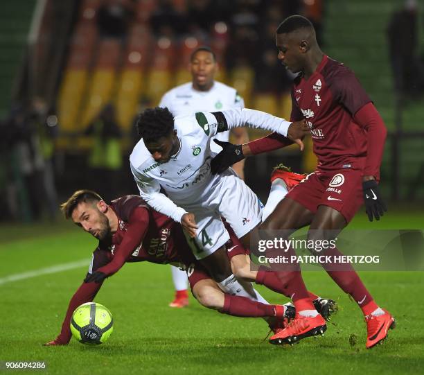 Metz's French defender Julian Palmieri and Metz' Senegalese defender Lemouya Goudiaby vie for the ball with Saint-Etienne's French forward Jonathan...