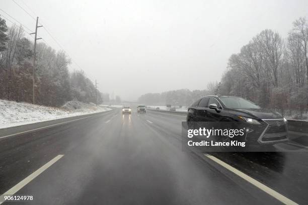 Vehicles move along Interstate 440 as snow falls on January 17, 2018 in Raleigh, North Carolina. Governor Roy Cooper declared a State of Emergency...