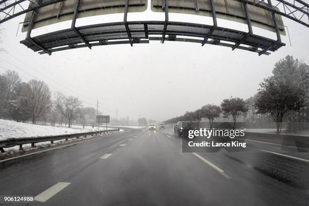 Vehicles move along Interstate 440 as snow falls on January 17, 2018 in Raleigh, North Carolina. Governor Roy Cooper declared a State of Emergency...