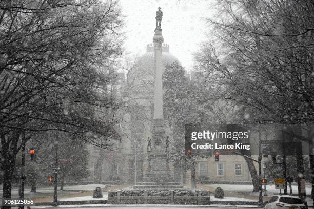 Snow falls on the Confederate Soldiers Monument at the State Capitol on January 17, 2018 in Raleigh, North Carolina. Governor Roy Cooper declared a...