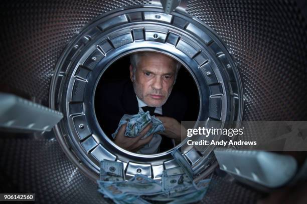 pov man taking us dollars out of a washing machine - money laundering stock pictures, royalty-free photos & images