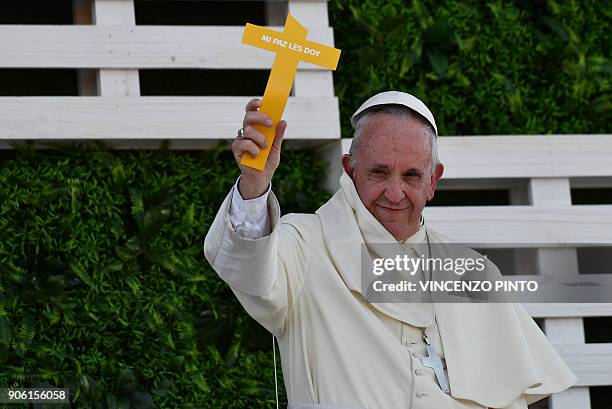Pope Francis waves to a crowd of faithfuls holding a paper cross that reads "I give you my peace", at the National Shrine of Maipu in Santiago during...
