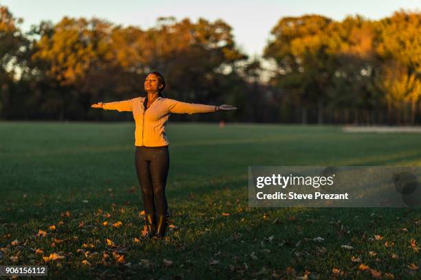 woman meditating in public park - steve prezant stock pictures, royalty-free photos & images