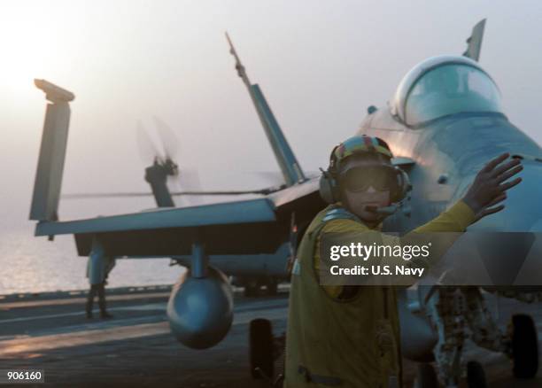 Aviation Boatswain's Mate 1st Class Larry Tarver from Gloucester, VA positions an F/A-18 "Hornet" Strike fighter jet on the flight deck of the...