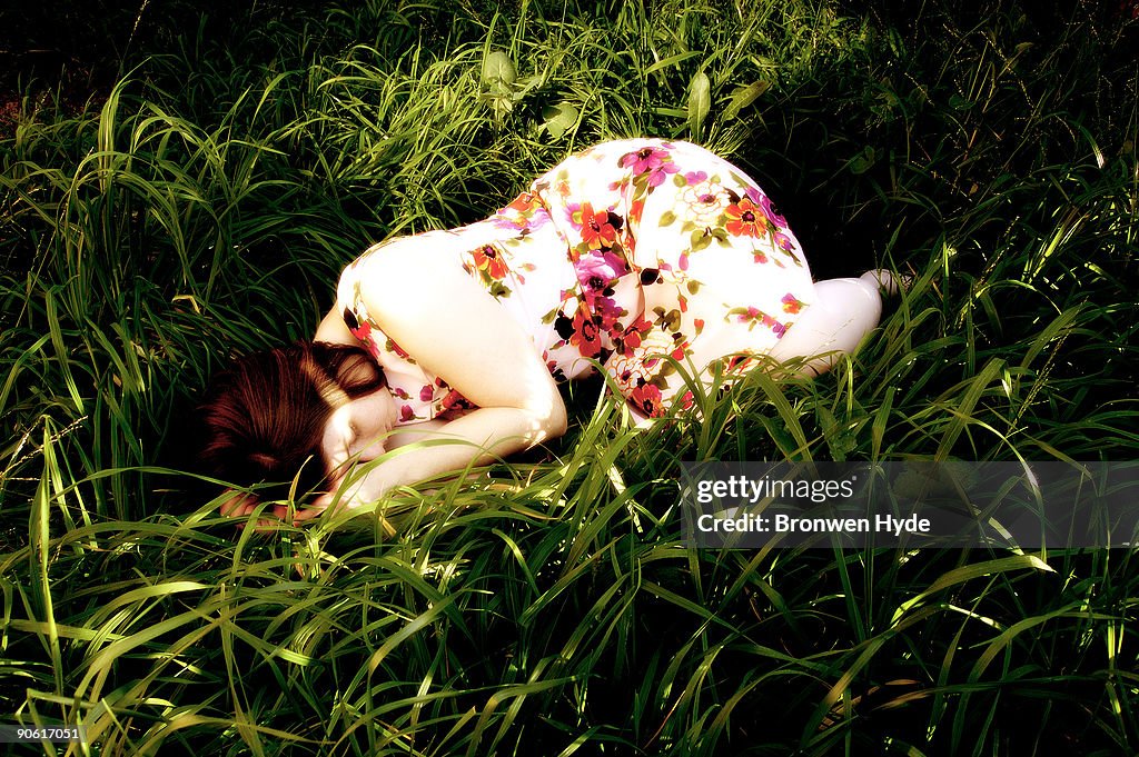 Woman in floral dress lying in the grass