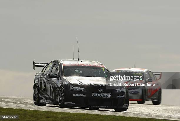 Todd Kelly driving the Kelly Racing Holden leads Craig Lowndes driver of the Team Vodafone Ford during race A for round nine of the V8 Supercar...
