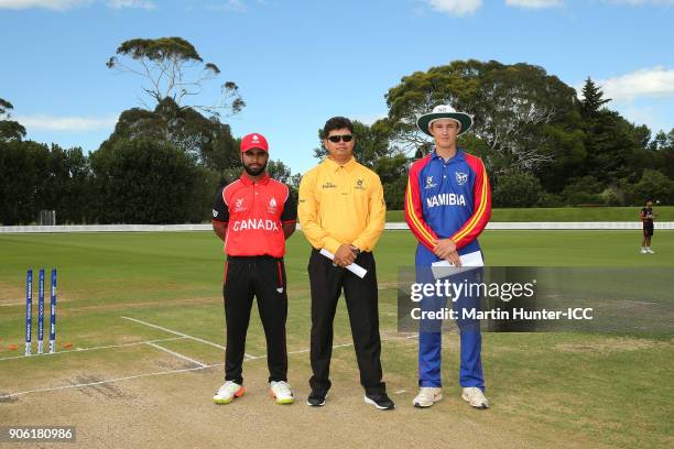 Arslan Khan of Canada, ICC Match Offical Devdas Govindjee and Lohan Louwrens of Namibia pose after the coin toss during the ICC U19 Cricket World Cup...