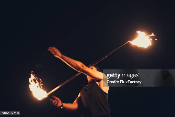 spinning a contact staff - fire performer stock pictures, royalty-free photos & images