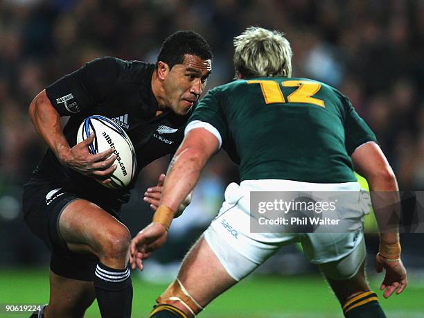 Mils Muliaina of New Zealand looks for a way past Jean De Villiers of South Africa during the Tri Nations Test between the New Zealand All Blacks and...