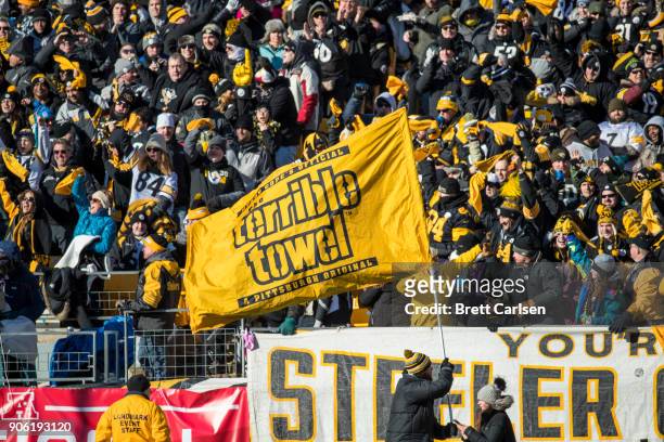 Pittsburgh Steelers fans cheer as a stadium staff member waves a Terrible Towel flag during the second quarter against the Jacksonville Jaguars in...