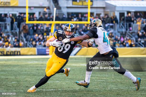 Vance McDonald of the Pittsburgh Steelers fends off Barry Church of the Jacksonville Jaguars during the third quarter of the AFC Divisional Playoff...