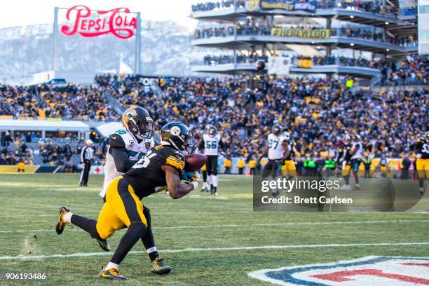 Le'Veon Bell of the Pittsburgh Steelers makes a touchdown reception in front of Telvin Smith of the Jacksonville Jaguars during the third quarter of...