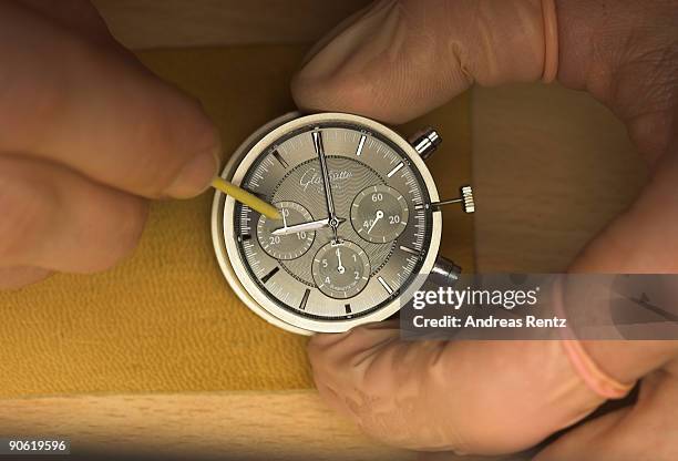 Watch maker of German watch manufacturer Glashuette Original adjusts a hour hand on an exemplar of the 'Glashuette Original Senator' watch on...