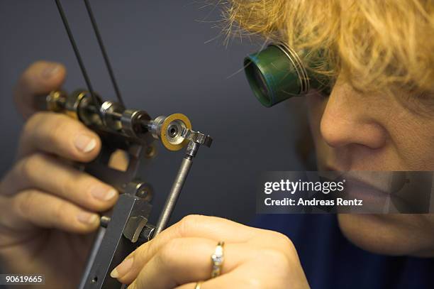 Watch maker of German watch manufacturer Glashuette Original polishes a component part of a watch on December 19, 2007 in Glashuette, near Dresden,...