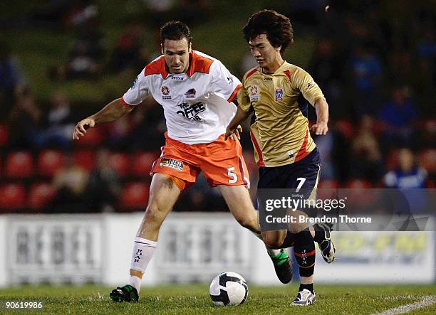 Jin-Hyung Song of the Jets competes with Josh McCloughan of the Roar during the round six A-League match between the Newcastle Jets and the Brisbane...