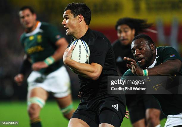 Dan Carter of New Zealand runs past Tendai Mtawarira of South Africa during the Tri Nations Test between the New Zealand All Blacks and South African...