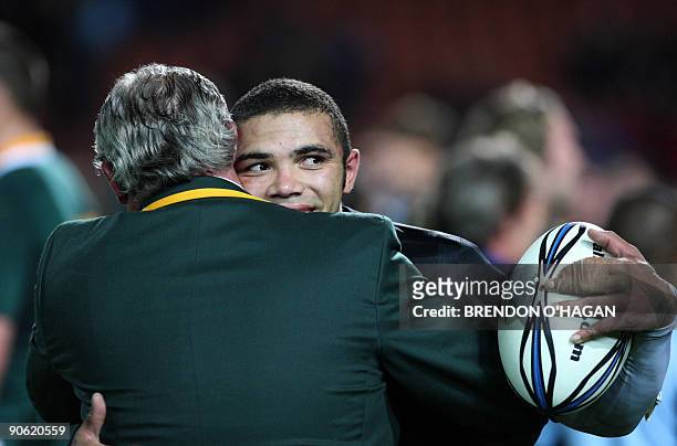 South African player Bryan Habana holds a ball as he embraces assistant team coach Gary Gold following the Springboks's victory over the New Zealand...