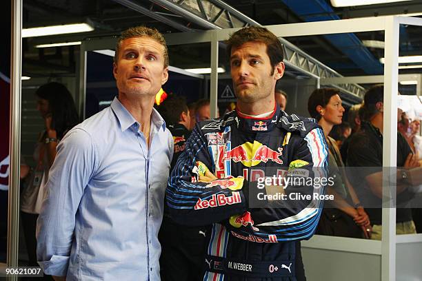 Mark Webber of Australia and Red Bull Racing talks with former F1 driver David Coulthard in his team garage during the final practice session prior...