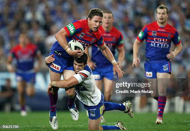 Kurt Gidley of the Knights is tackled during the third NRL qualifying final match between the Bulldogs and the Newcastle Knights at ANZ Stadium on...