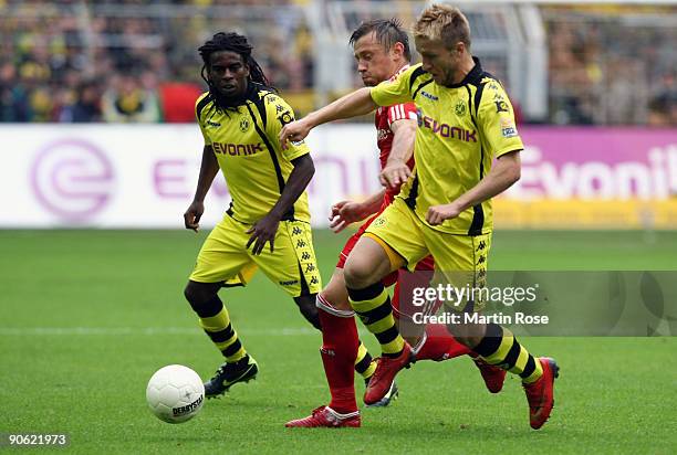 Tinga and Jakub Blaszczykowski of Dortmund battle for the ball with Ivica Olic of Muenchen battle for the ball during the Bundesliga match between...